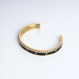 Sultana Cuff Black & Gold, close-up of the engraved EZELE emblem on the black and gold cuff