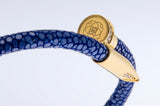 Close-up of the gold nail clasp and engraved EZELE emblem on the Wrap Soudage Blue & Gold