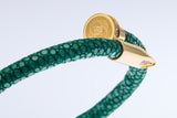 Close-up of the gold nail clasp and engraved EZELE emblem on the Wrap Soudage Green & Gold